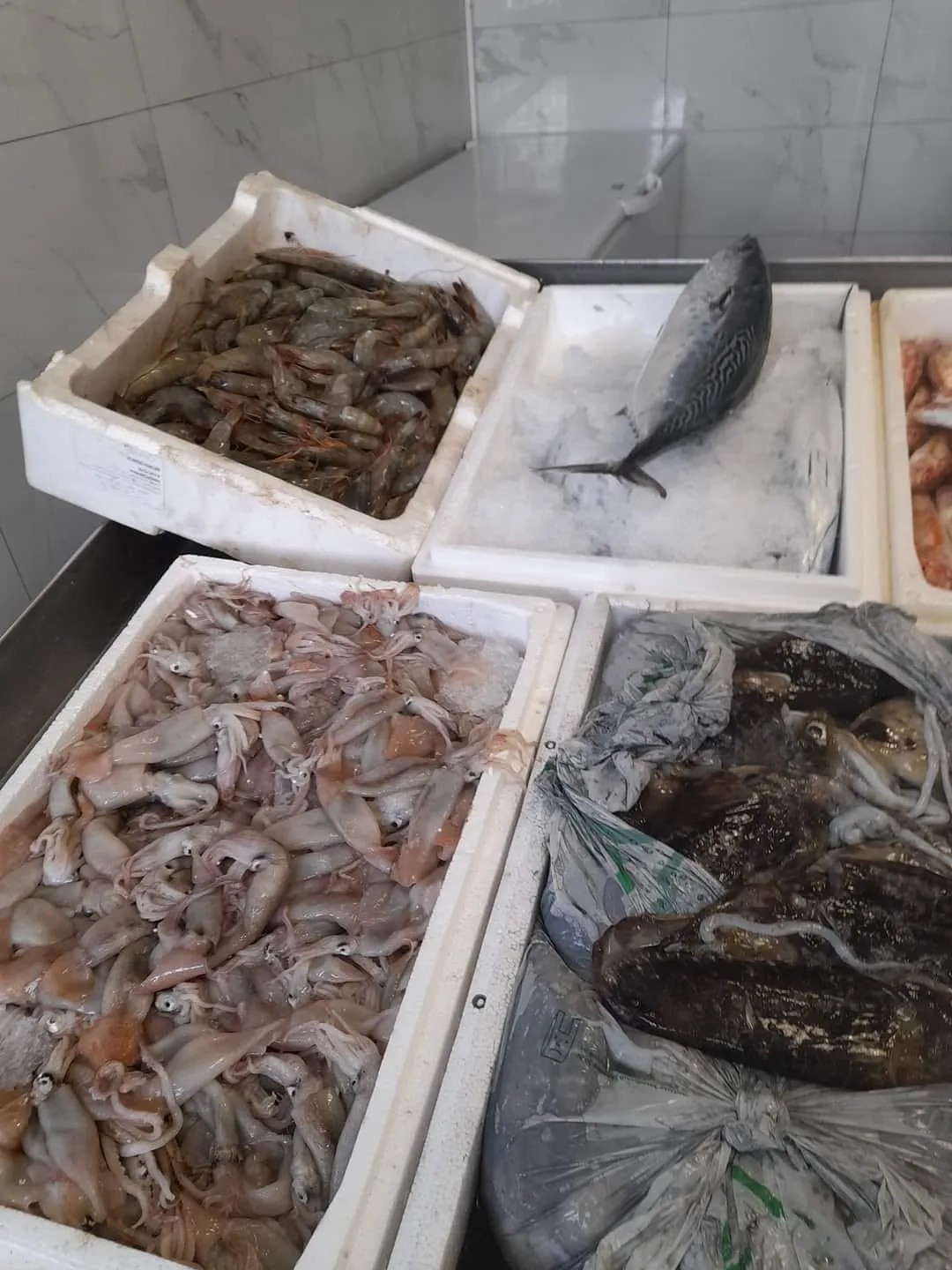 Professional fishmonger preparing fresh catch for customers at Skiathos Fish Market